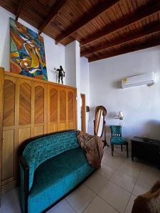 圣安德烈斯Sunset Paradise的一间卧室配有绿色沙发和墙上的绘画