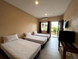 达拉盖地Ocean Bay Beach Resort的酒店客房设有两张床和一台平面电视。