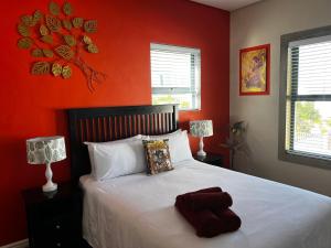兰格班Clam Lagoon的一间卧室设有红色的墙壁和一张带两盏灯的床。
