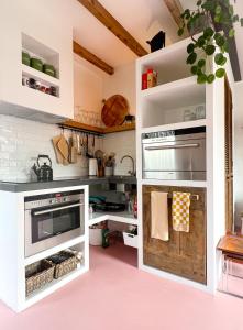鹿特丹Guesthouse Rotterdam, tinyhouse nearby Kralingen的厨房配有白色橱柜和粉红色地板