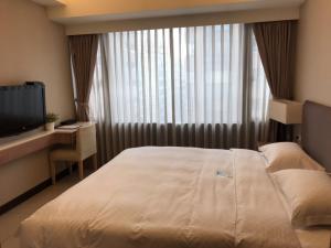 台北AJ Residence 安捷國際公寓酒店的一间卧室配有一张大床和电视