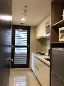 台北AJ Residence 安捷國際公寓酒店的厨房设有门,里面装有窗户