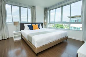 华欣First Choice Suites SHA Plus Extra的卧室设有一张带窗户的白色大床