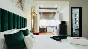 诺伊达Olive Service Apartments - City Centre Noida的一间卧室配有一张白色大床和绿色床头板