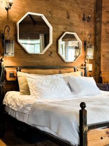 莫沙夫拉莫特Crimson View的卧室配有一张床铺,墙上挂有两面镜子