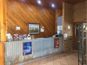 温顿Boulder Opal Motor Inn的木墙建筑的售票柜台