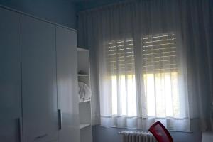 马尔托雷尔Habitació B Cal Kim的客房设有带白色窗帘和散热器的窗户。