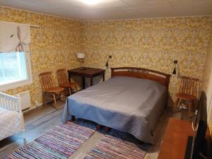 EuraPunavilla Cottage的卧室配有一张床和一张桌子及椅子