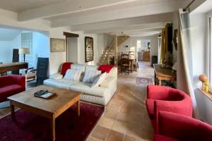 贝诺代Maison de famille près de la mer的客厅配有白色沙发和红色椅子