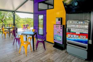 斯库库扎SleepOver Kruger Gate的餐厅设有紫色桌椅和爆米花机