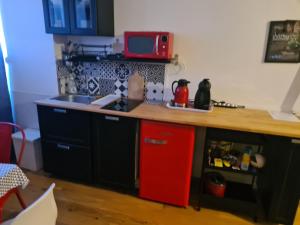 亚眠Escapade Amiens的厨房配有红色冰箱和台面