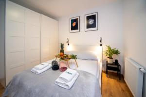 格但斯克Maya's Flats & Resorts 49 - 3 rooms flat in Szafarnia Gdansk的一间卧室配有两张床、毛巾和桌子