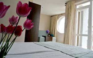 巴尔奇克Valeo Hotel的一间房间,床上有粉红色的鲜花