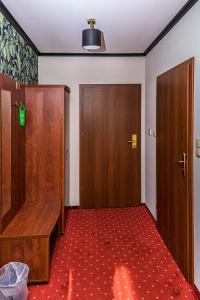 利岑Hotel Stara Gorzelnia的一间设有两个木门和红地毯的房间