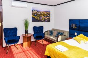 利岑Hotel Stara Gorzelnia的酒店客房配有一张床、两把椅子和一张沙发
