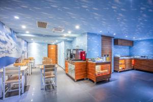 台北云沐行旅 Hotel Cloud Arena-Daan的厨房拥有蓝色的墙壁和木制桌椅