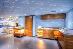 台北云沐行旅 Hotel Cloud Arena-Daan的厨房设有蓝色的墙壁、木制橱柜和桌子。