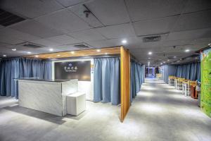 台北云沐行旅 Hotel Cloud Arena-Daan的一间设有蓝色窗帘和长走廊的客房