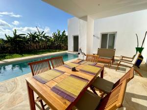 吉汶瓦Manami Villa with Private Pool ZanzibarHouses的一间带桌椅的用餐室和一个游泳池