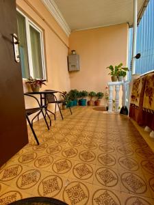 巴统Family Home的客房铺有瓷砖地板,配有椅子和植物