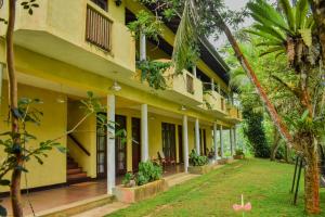 KudaweBlue Magpie Lodge Sinharaja的享有带庭院的建筑的外部景色