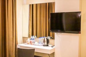 巴淡岛中心OS Hotel Airport Batam的一间酒店客房,配有一张桌子和一台电视