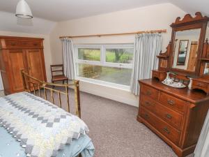 彭布罗克码头Nash Lodge的一间卧室配有一张床、一个梳妆台和一扇窗户。