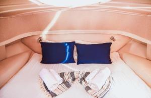博德鲁姆The Opportunity to Live on a sailing yacht in Bodrum Marina的一张带两个枕头和一双鞋的床