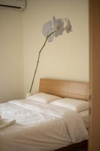 特里卡拉DimSim Home-Σπίτι με όνομα的卧室配有一张挂着鲜花的床