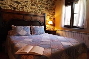 Aldeanueva de la SierraLos Monteros Sierra de Francia的一间卧室配有一张床铺,上面有一本开放式书籍