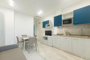 里乔内Residence Flow-R的厨房配有蓝色橱柜和桌椅