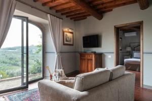 因普鲁内塔Relais Villa Olmo的带沙发和大窗户的客厅