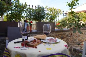 Aldeanueva de la SierraLos Monteros Sierra de Francia的一张桌子,上面放着两杯酒和一盘食物