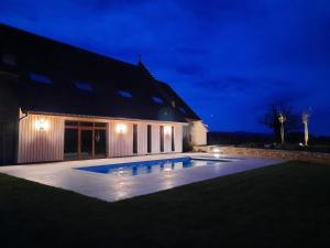 CourlaouxDomaine du moulin de Jeanne的一座晚上设有游泳池的房子
