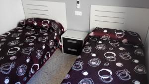马尼尔瓦马尼尔瓦奥卡尼亚旅馆的一间卧室配有两张床和一个盒子