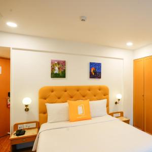 孟买Bloom Boutique - Bandra的一间卧室配有一张带橙色枕头的床
