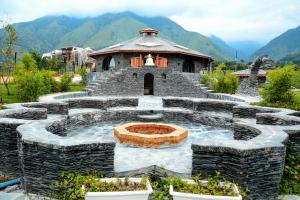 康格拉Osho Himalayas Wellness Resort的中间有喷泉的石头建筑