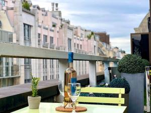 巴黎Champs Élysées-Belle terrasse, luxueux appartement的一张桌子上坐着一瓶葡萄酒和一杯