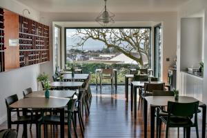 大里贝拉Volcanic Charming House的餐厅设有桌椅和大窗户。