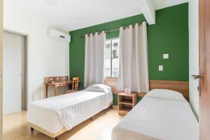 圣玛丽亚Hotel Dom Rafael Express的一间卧室设有两张床和绿色的墙壁