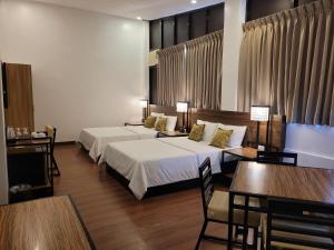 科隆Fernvale Leisure Club and Resort的酒店客房带两张床和一张桌子以及椅子。