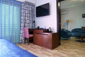 达喀尔拉斐尔特2号酒店的酒店客房设有一张桌子和一台墙上的电视