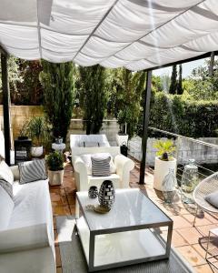 戈赖斯Estilosa casa golf的白色遮阳伞下的带白色家具的庭院