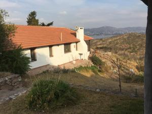 维拉帕尔克西基曼Casa campestre – Lago azul的山坡上一座白色房子,屋顶橙色