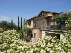 拉波拉诺泰尔梅Villa Il Fornacino的一座古老的石头房子,设有阳台和鲜花