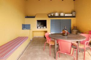 JunqueiraCasa Cristina的一间带桌子和粉红色椅子的用餐室