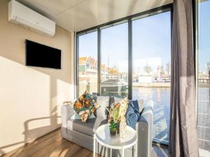 福伦丹Inviting houseboat in Volendam with shared pool的带沙发和大窗户的客厅