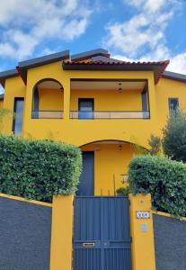 丰沙尔Villa Strelitzia的蓝色门的黄色房子