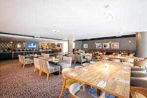 考文垂克文特日M6J2度假旅馆的一间带桌椅的餐厅和一间酒吧