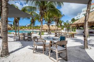 Blue BayBlue Bay BEACH Villa 25 3-min beach-pool-golf的海滩上的餐厅,配有桌椅